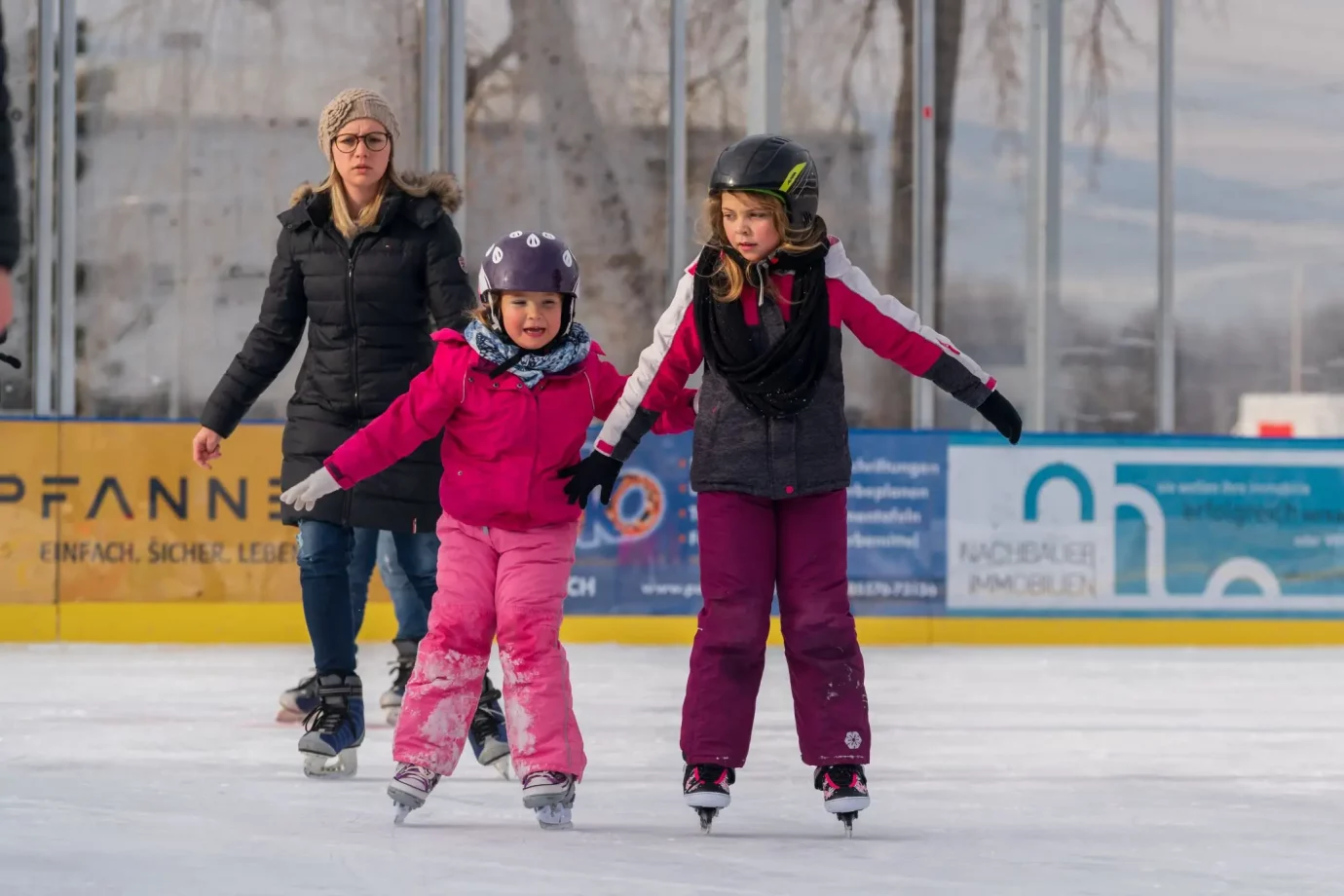 Zwei Kinder die Eislaufen auf dem Eislaufplatz